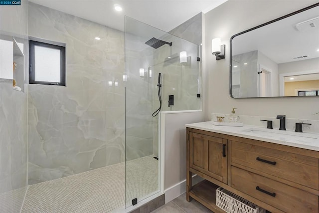 bathroom featuring vanity, a tile shower, and tile patterned floors