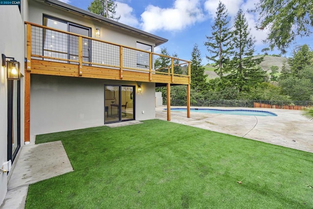 rear view of house featuring a yard, a fenced in pool, and a patio