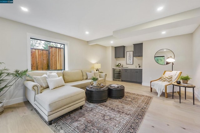 living room featuring indoor wet bar, beverage cooler, and light hardwood / wood-style floors