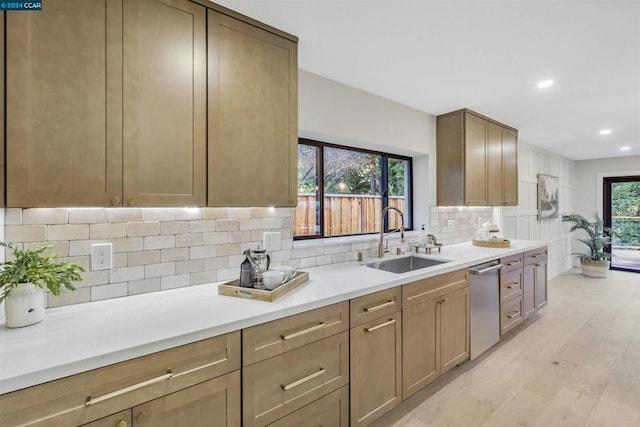 kitchen with tasteful backsplash, stainless steel dishwasher, light hardwood / wood-style floors, and sink