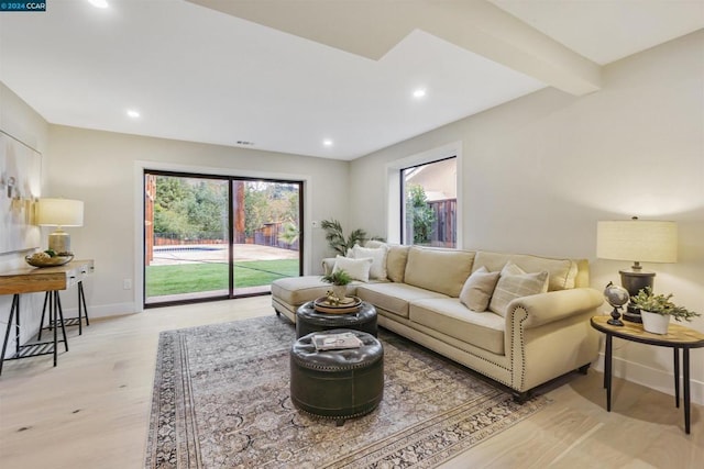 living room featuring beam ceiling and light hardwood / wood-style flooring