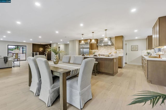 dining space with sink and light hardwood / wood-style floors