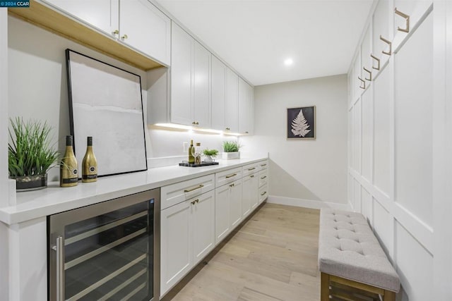 bar featuring white cabinetry, beverage cooler, and light wood-type flooring