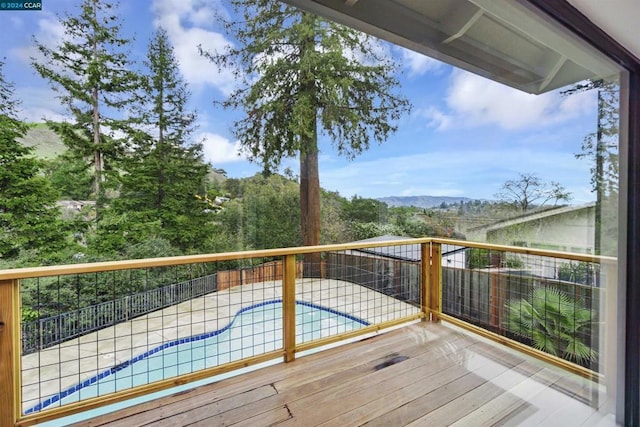 deck with a pool, a mountain view, and a patio