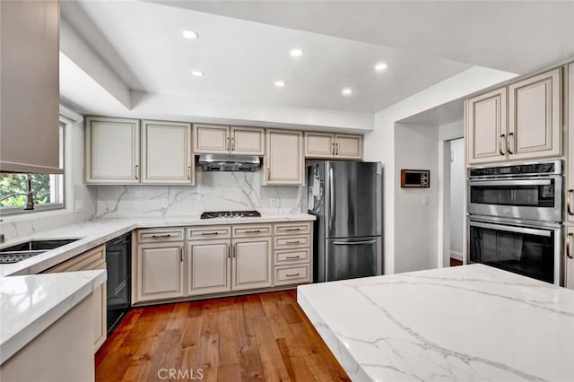 kitchen featuring light stone counters, sink, and stainless steel appliances