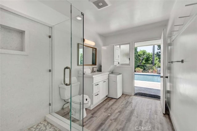 bathroom featuring toilet, a shower with shower door, hardwood / wood-style floors, and vanity