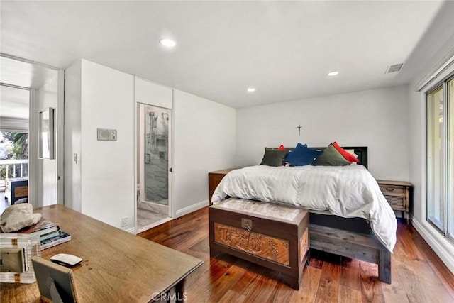 bedroom with dark hardwood / wood-style flooring and connected bathroom