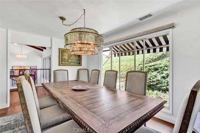 dining space with an inviting chandelier and hardwood / wood-style floors