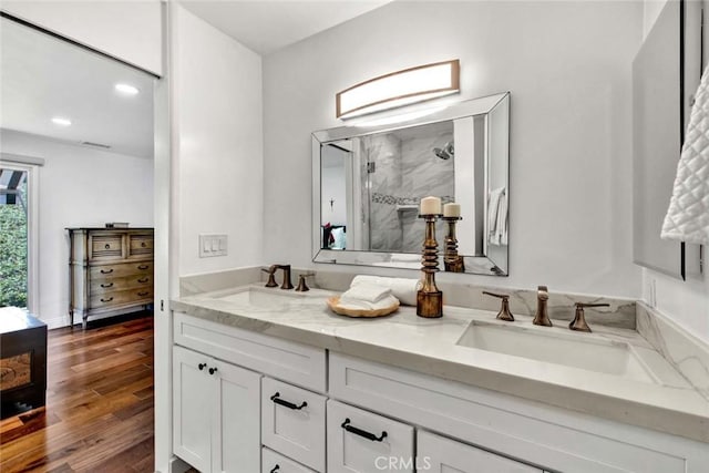 bathroom featuring vanity, wood-type flooring, and a shower