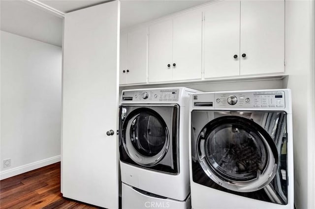 laundry area with cabinets, dark hardwood / wood-style flooring, and washing machine and dryer