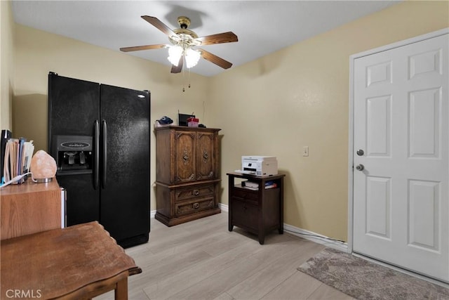 kitchen with black refrigerator with ice dispenser, light hardwood / wood-style floors, and ceiling fan