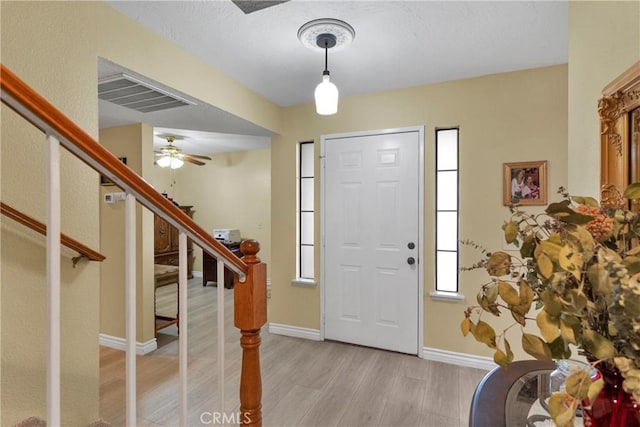 foyer with ceiling fan and light hardwood / wood-style flooring