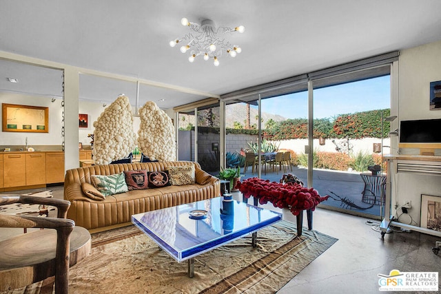 living room with floor to ceiling windows, a healthy amount of sunlight, concrete floors, and an inviting chandelier