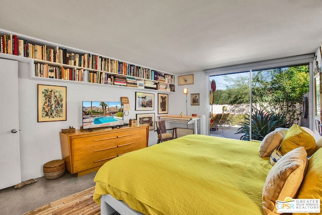 bedroom featuring access to exterior and a wall of windows