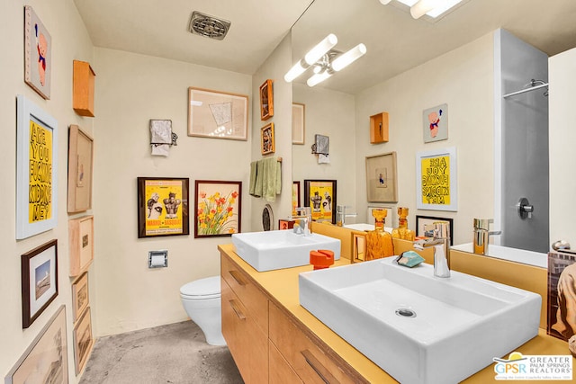 bathroom with vanity, toilet, and concrete floors