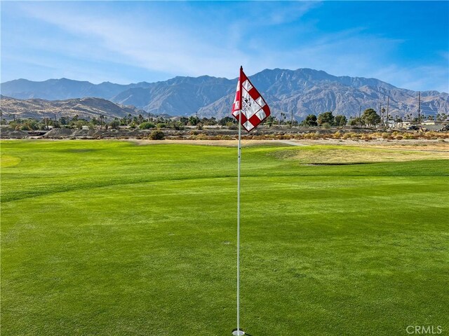 view of property's community with a mountain view and a lawn