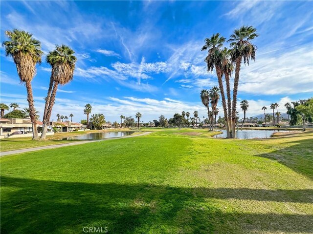 view of property's community with a water view and a yard