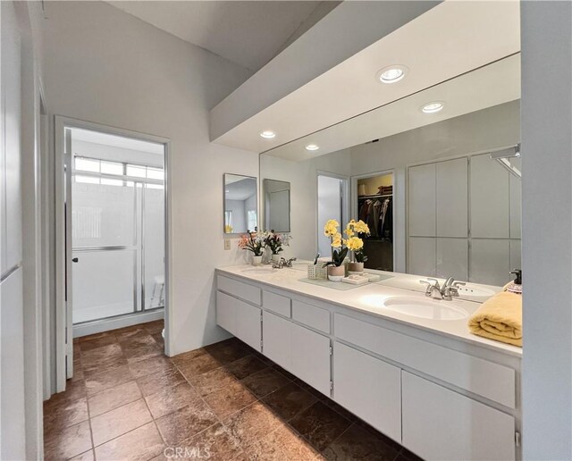 bathroom featuring walk in shower and vanity