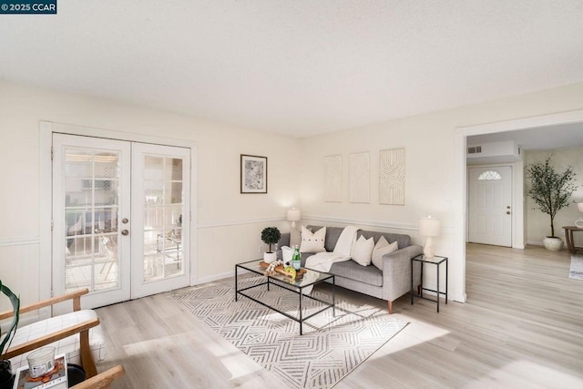 living room with french doors and light hardwood / wood-style floors