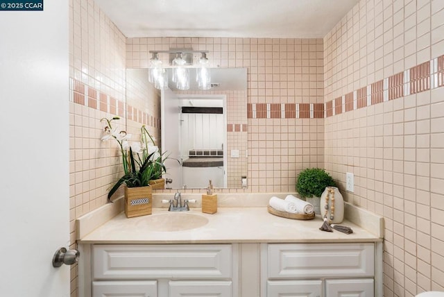 bathroom featuring vanity and tile walls