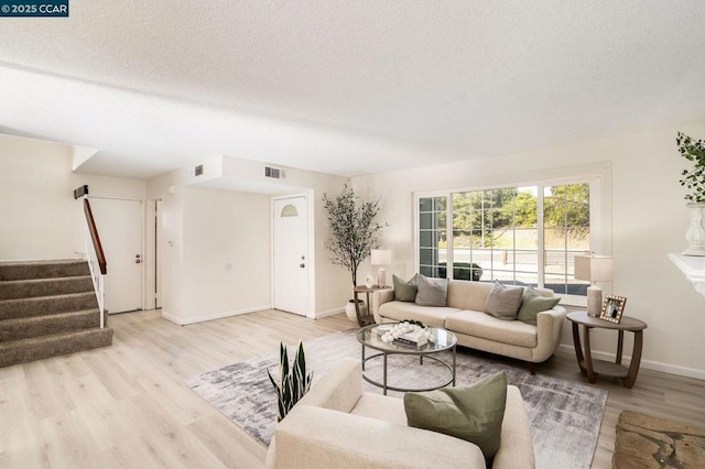 living room with light hardwood / wood-style floors and a textured ceiling