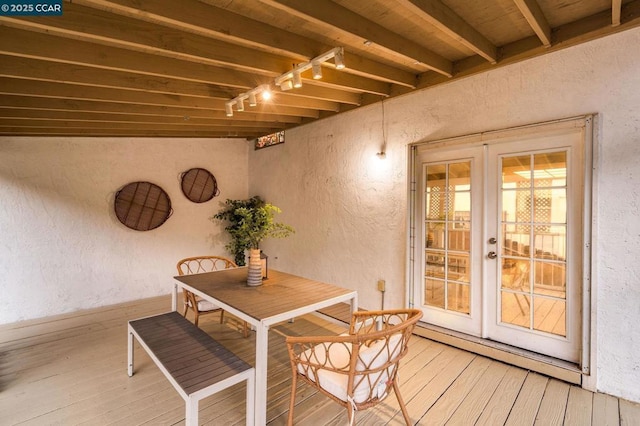 dining space featuring beamed ceiling, rail lighting, a baseboard heating unit, and hardwood / wood-style flooring