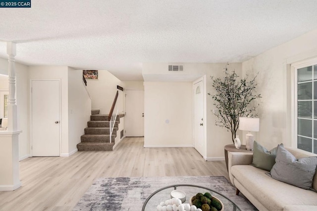 living room with a textured ceiling and light hardwood / wood-style floors