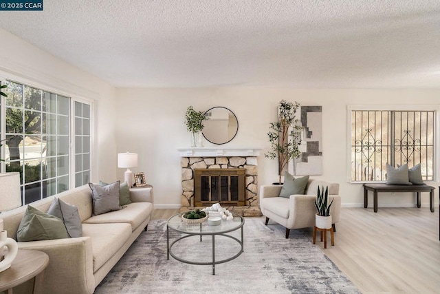 living room with a fireplace, a textured ceiling, and hardwood / wood-style flooring