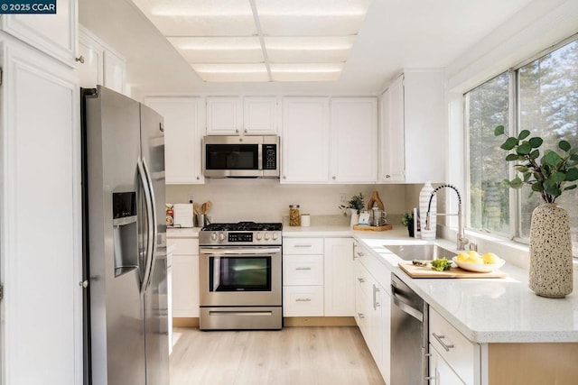 kitchen featuring white cabinets, a wealth of natural light, sink, and appliances with stainless steel finishes