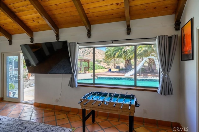 recreation room featuring beam ceiling, tile patterned flooring, and wood ceiling