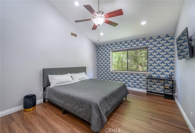 bedroom with ceiling fan, vaulted ceiling, and hardwood / wood-style floors