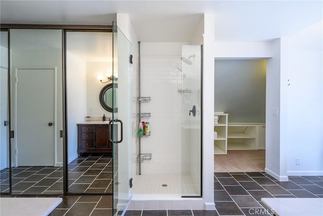 bathroom with a shower with shower door and vanity