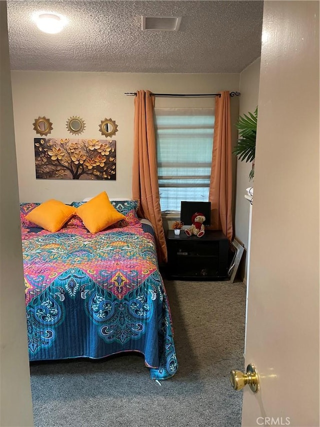 bedroom featuring a textured ceiling and carpet flooring