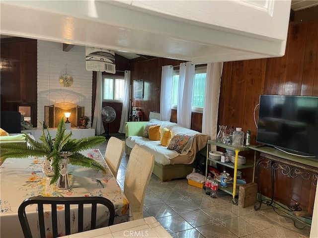 tiled living area with beamed ceiling and wood walls