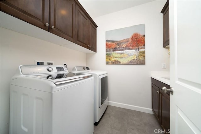 clothes washing area featuring separate washer and dryer and cabinets