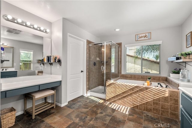 bathroom featuring vanity, independent shower and bath, and a healthy amount of sunlight