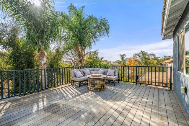 wooden deck with an outdoor living space with a fire pit