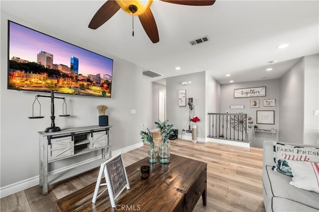 living room with ceiling fan and hardwood / wood-style flooring