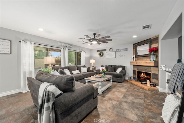 living room featuring ceiling fan and a large fireplace