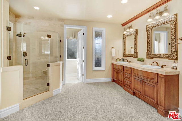 bathroom featuring a shower with shower door and vanity