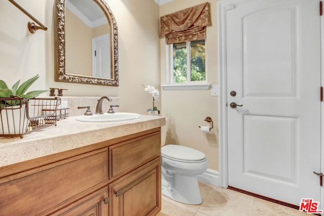 bathroom with tile patterned floors, toilet, vanity, and ornamental molding