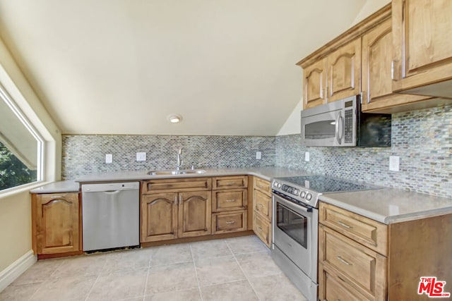 kitchen featuring light tile patterned floors, stainless steel appliances, decorative backsplash, and sink