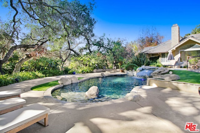 view of swimming pool featuring pool water feature and a patio