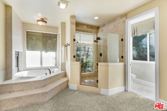 bathroom featuring plus walk in shower and toilet