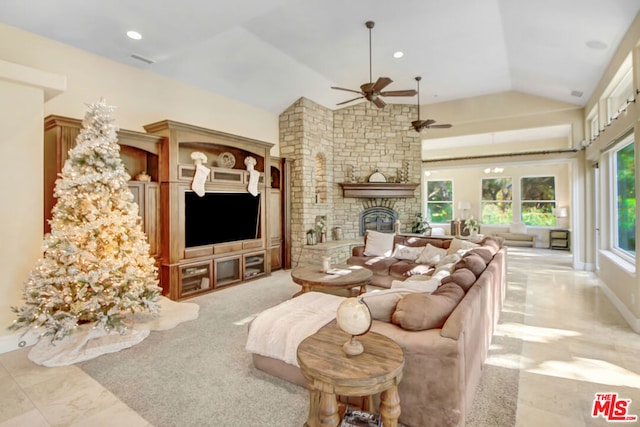 living room featuring ceiling fan, a fireplace, and lofted ceiling