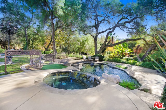 view of swimming pool with an in ground hot tub