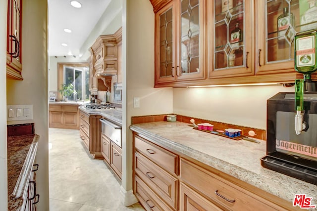 kitchen with light tile patterned floors and light stone countertops