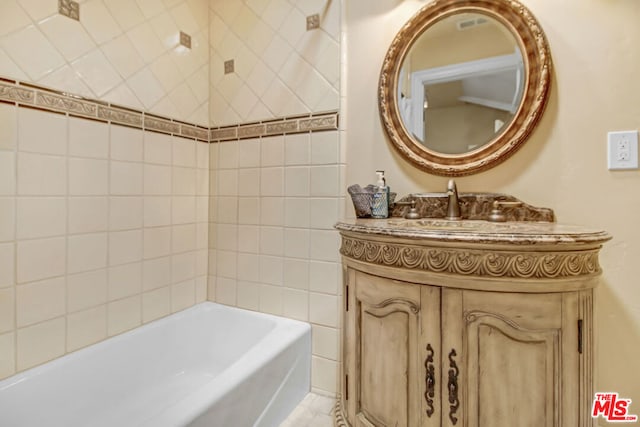 bathroom with a tub and vanity