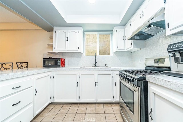 kitchen with stainless steel gas range, sink, a tray ceiling, custom range hood, and white cabinets