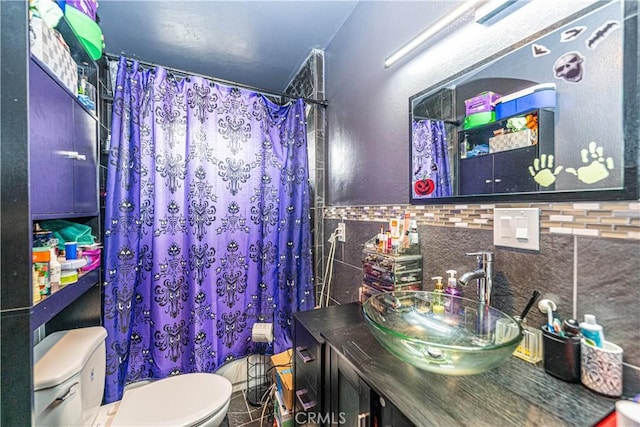 bathroom with toilet, sink, and tile walls